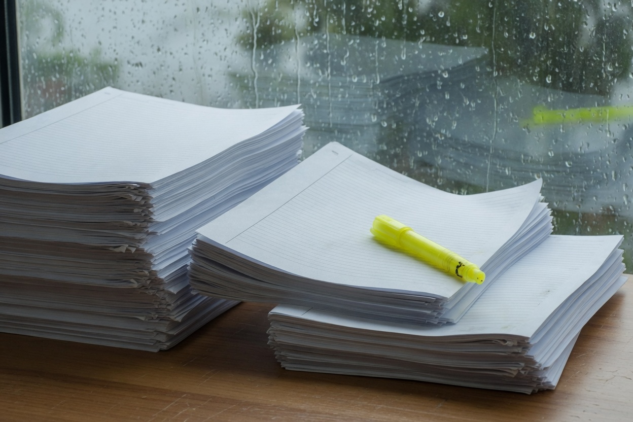 Printed contractor bids and a highlighter spread across a desk